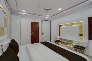 a bedroom with a large white bed and a tv at Hotel O OM SAI HOTEL in Kākori