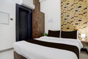 a bedroom with a large bed with a black and white comforter at Hotel O Shad Residency in Patna