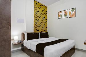 a bedroom with a large bed and a yellow wall at Hotel O Shad Residency in Patna +23 photos