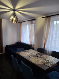 ein Esszimmer mit Tisch und Couch in der Unterkunft Apartament pod Czarną Górą in Stronie Śląskie