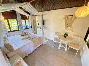 a bedroom with a bed and a table at Pousada Encontro das Águas in Maragogi +51 photos