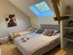 2 Betten in einem Schlafzimmer mit Dachfenster in der Unterkunft Le Verger Des Pierres Blanches,11 chambres,11 wc, 8 sdbs,pool chauffée 11 m 35p in Mont-près-Chambord + 49 Fotos