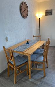 a wooden table with chairs and a clock on the wall at Wohnung VS in Villingen-Schwenningen