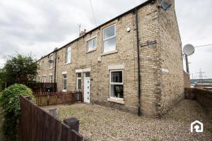 une maison en briques avec une clôture devant elle dans l'établissement The Ryton Free Wi-fi Parking, à Winlaton