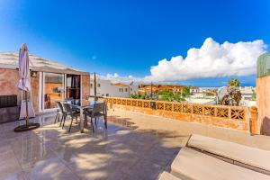 eine Terrasse mit Tisch und Stühlen auf einem Balkon in der Unterkunft Semi-detached villa sea views, huge terrace, close beach in Palm-mar