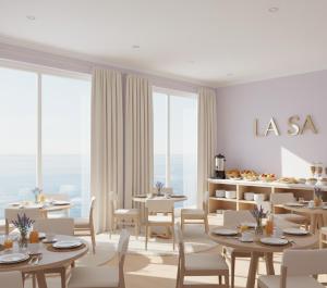 a dining room with tables and chairs and large windows at La-Sa Apart Hotel in Icmeler