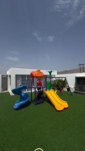 un parque infantil con tobogán y columpio en شالية القمر, en Wāsiţ