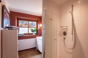 une salle de bain avec douche et lavabo dans l'établissement 4-Jahreszeiten, à Hopfgarten im Brixental 31 autres photos