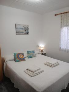 a bedroom with a bed with towels on it at L'Hortet de Can Serra in Santander