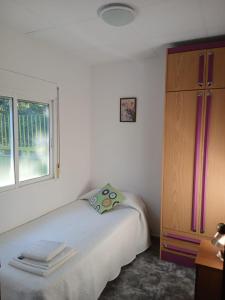 a bedroom with a bed and a dresser and a window at L'Hortet de Can Serra in Santander