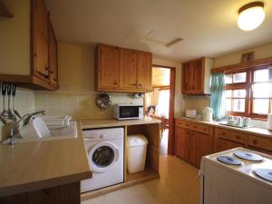 Sea PallingにあるMeadow Viewのキッチン(木製キャビネット、洗濯機、乾燥機付)