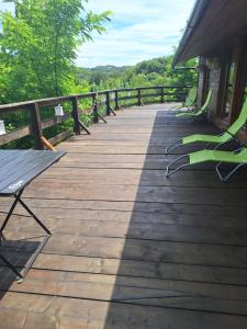 a wooden walkway with chairs and a bench on it at Cabana Montesanto- explora y alegrate in Preluca Nouă