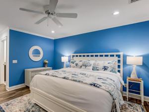ein blaues Schlafzimmer mit einem Bett und einem Deckenventilator in der Unterkunft Crawford Coastal in Savannah + 13 Fotos