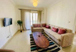 a living room with a couch and a coffee table at A Home to Sleep Wi-Fi AC in Madinaty