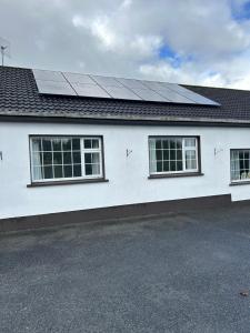 a white house with solar panels on the roof at Haralyn in Bunclody