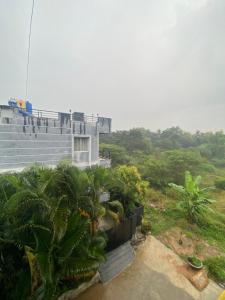 a building with palm trees in front of it at Irishhome stay in Hosūr
