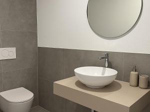 a bathroom with a sink and a toilet and a mirror at Tirola Hütte in Alpbach