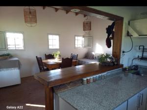 een keuken met aanrechtblad en een woonkamer bij La Chacra in Pilar