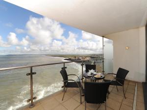 a balcony with a table and chairs and the ocean at Tidal Bay in Westward Ho