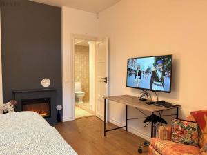 een woonkamer met een flatscreen-tv aan de muur bij Free Parking l Electric Chimney l Everything nearby in Pärnu