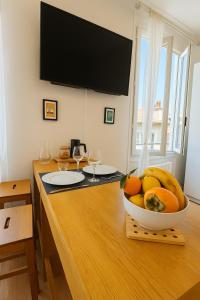 a bowl of fruit on a wooden table with a television at Côté Vieil Antibes in Antibes +7 photos