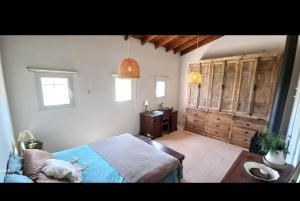 een slaapkamer met een bed, een dressoir en ramen bij La Chacra in Pilar