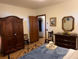 una camera da letto con un letto, un comò e uno specchio di Assisi, la Noce ad Assisi