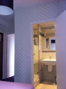 a bathroom with a sink and a toilet and a shower at Logis Terrasse Hôtel in Lisieux