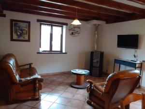a living room with two chairs and a tv at Gîte ETXOLA in Saint-Étienne-de-Baïgorry