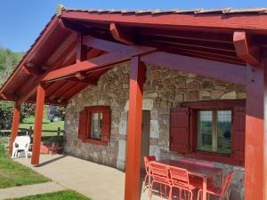 サン・テティエンヌ・ド・バイゴリにあるGîte ETXOLAの建物の前にパティオ(テーブル、椅子付)