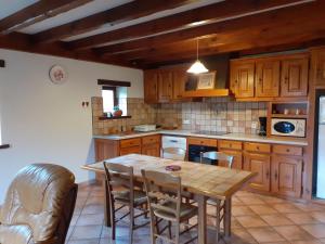 a kitchen with wooden cabinets and a wooden table and chairs at Gîte ETXOLA in Saint-Étienne-de-Baïgorry