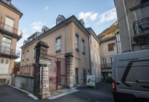 een busje geparkeerd op een parkeerplaats naast een gebouw bij Le 14 De Pic in Cauterets