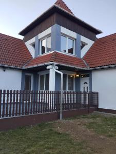 a house with a wooden fence in front of it at NADENKA & MGR Vendégház in Alsótelekes