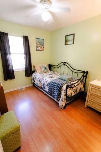 une chambre avec un lit et un parquet dans l'établissement Blue Heron Cottage with Game Room, Deck & Hot Tub, à Logan