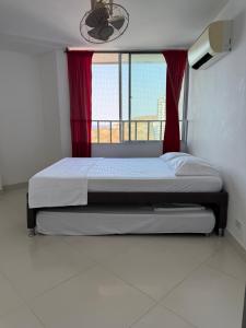ein Bett in einem Zimmer mit einem großen Fenster in der Unterkunft Apartamento en el Rodadero in Santa Marta + 14 Fotos