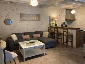 a living room with a blue couch and a bar at Jolie fermette a 2 min du circuit de Magny Cours in Saint-Parize-le-Châtel