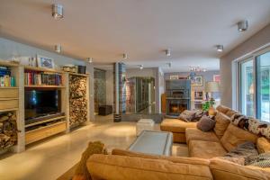 a large living room with couches and a tv at Villa La Chauve Souris in Houffalize