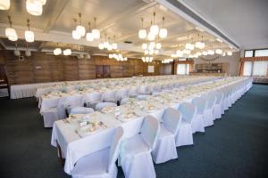 a large banquet hall with white tables and chairs at Hotel Harmonie in Luhačovice +25 photos