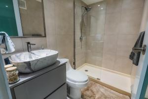 a bathroom with a sink and a toilet and a tub at Isla | The Sunset Abode in Ocean Club, Rincón in Corcega +17 photos