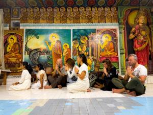Eine Gruppe von Menschen sitzt vor einer Wand mit Gemälden. in der Unterkunft Safaria Lodge Wilpattu in Pahala Maragahawewa