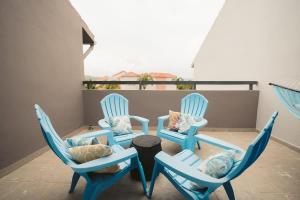 three blue chairs and a table on a balcony at Selah | Travelers Nesters in Palmas Del Mar in Buena Vista
