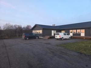 two cars parked in a parking lot in front of a house at Aurora Andøya Suites in Andøya