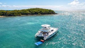 a white boat in the water near an island at Cayenne | Cozy Apt | Generator/Cistern | Bayamón in Forest Hills +11 photos