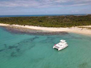 a white boat in the water next to a beach at Cayenne | Cozy Apt | Generator/Cistern | Bayamón in Forest Hills +11 photos