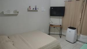een slaapkamer met een bed en een flatscreen-tv bij Espaço Acalanto in Rio das Ostras