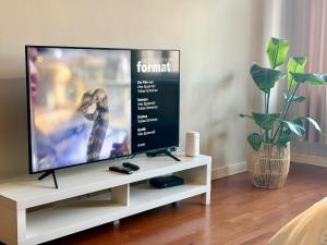 einen Flachbild-TV auf einem weißen TV-Stand in der Unterkunft Kawka i herbatka in Zielona Góra