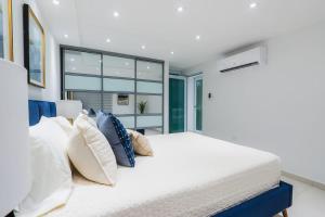 a bedroom with a large white bed with pillows at Isla | The Sunset Abode in Ocean Club, Rincón in Corcega