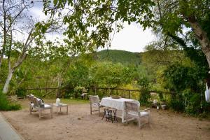 a table and chairs in a yard with a view at La casita del oso in Linares de la Sierra