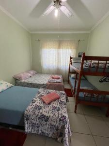 a bedroom with three beds and a ceiling fan at Hostel e Pousada Vó Lili in Joinville