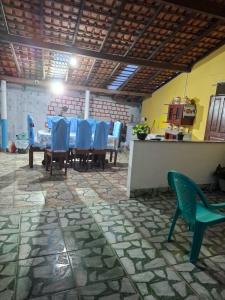 Un comedor con una mesa y sillas azules. en Pousada Marudá, en Marapanim
